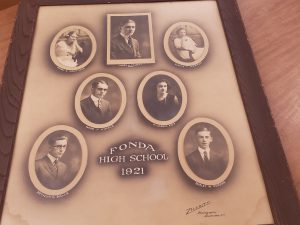 A framed compilation of seven photographs showing the Fonda High School Class of 1921