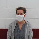 portrait of a mental health counselor with short hair standing in a school hallway