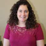 portrait of a school counselor with curly dark hair seated in a chair