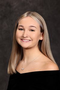 portrait of a high school student wearing a black top with long blonde hair