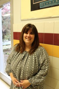 portrait of a middle school teacher standing in a school hallway