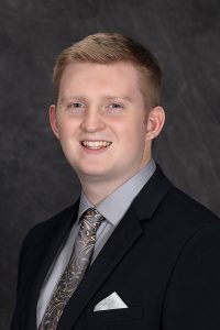 portrait of a high school student wearing a suit and tie with short blonde hair