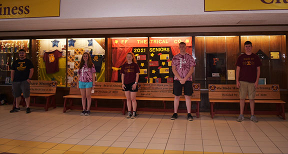 Students stand in front of benches