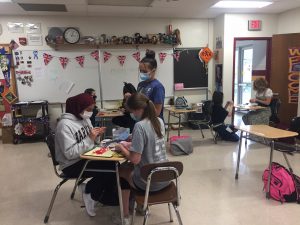 Yellow Roses team members putting together pink ribbons to support Pink Day on Friday, Oct. 22.