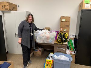 FFCS School Social Worker Mrs. Capron posing with packaged goods to be distributed as part of the district's backpack food program.