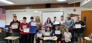 FFHS Math Department members with high school students holding up their brackets during March Madness.