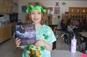 FFES student posing with a copy of John Gray's latest book Sweet Polly Petals.