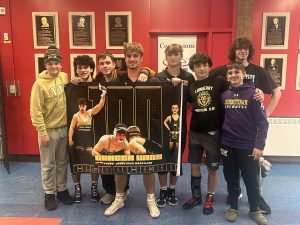 FFCSD wrestling members celebrating Colin Pickering's 100th win achievement.